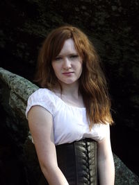 Portrait of beautiful woman standing against rocks