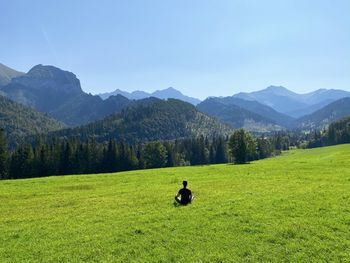 Man on field by mountain against sky