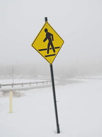 Road sign on snow covered field