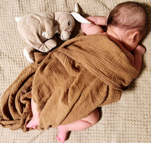 High angle view of baby girl lying on bed at home