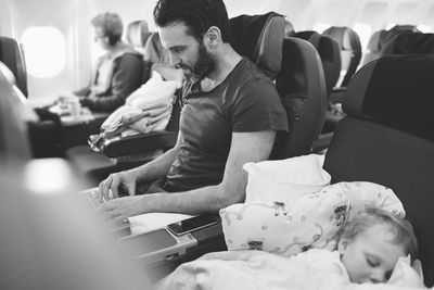 Man in plane using laptop
