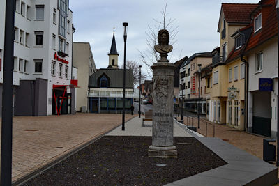 Statues on street amidst buildings in city