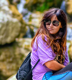 Young woman wearing sunglasses sitting outdoors