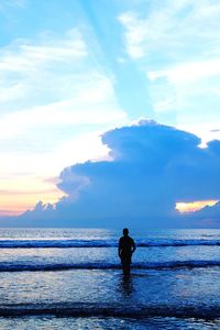 Silhouette man standing on beach against sky