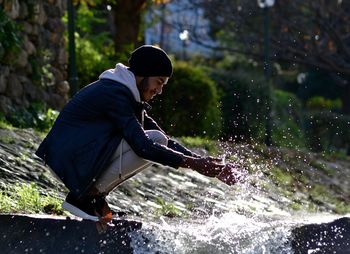 Man splashing water in stream