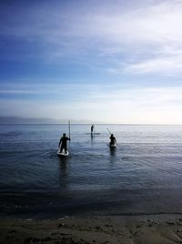 People in sea against sky