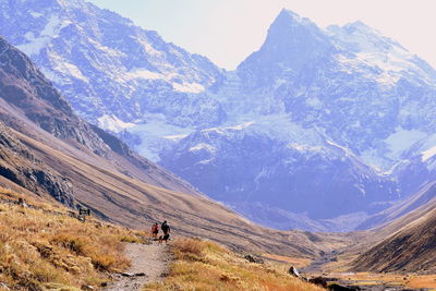 People on snowcapped mountains against sky