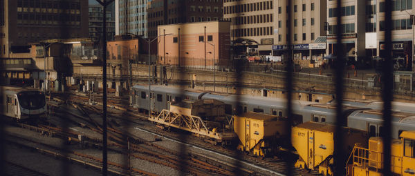 Train on railroad tracks by buildings in city