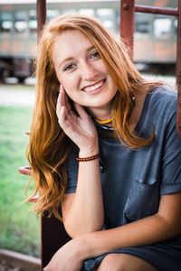 Portrait of a smiling young woman sitting outdoors