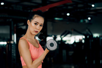 Portrait of woman standing against blurred background