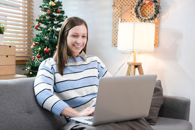 Young woman using laptop while sitting at home