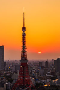 Tower and buildings against sky during sunset