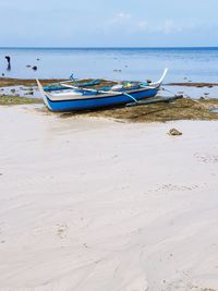 Boats moored on beach against sky