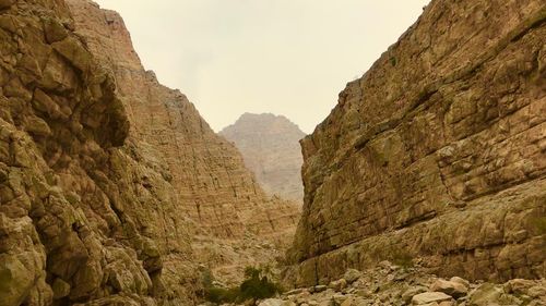 Low angle view of rocky mountains against sky