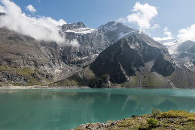 Scenic view of lake and snowcapped mountains against sky