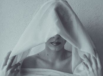 Close-up portrait of young woman on bed