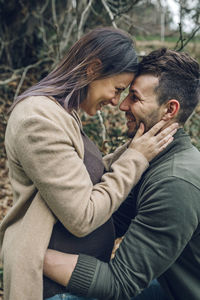 Man with smiling pregnant woman in nature