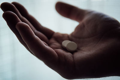 Close-up of cropped hand holding medicines at home