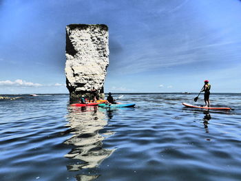 Men on boat in sea against sky