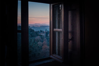 Buildings seen through window at sunset