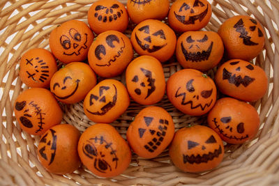 Healthy trick or treat halloween snacks for kids - basket of mandarin oranges jack o lantern faces