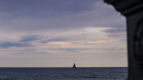 Sailboat sailing on sea against sky during sunset