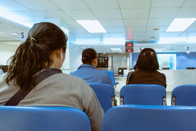 Rear view of people sitting at airport