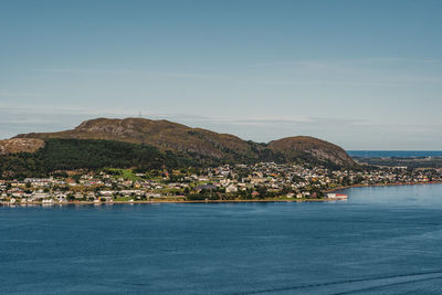 Scenic view of sea by town against sky