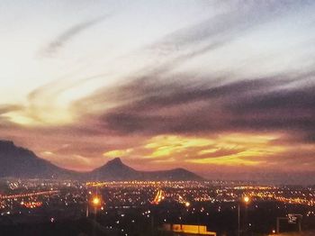 View of cityscape against cloudy sky