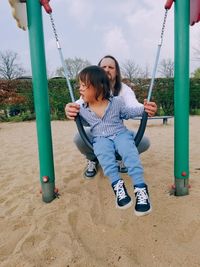 Portrait of boy swinging boy at playground