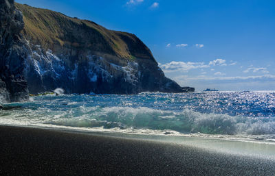 Scenic view of sea and cliffs against sky