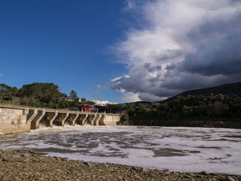 Arch bridge over river against sky