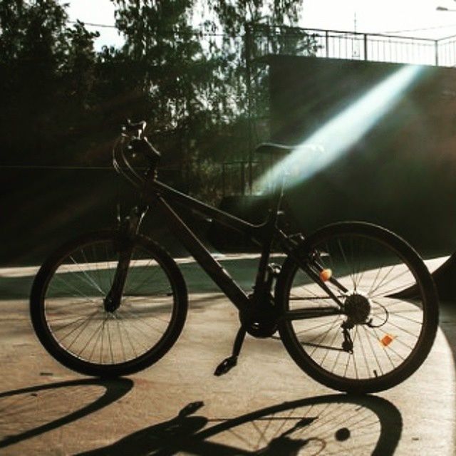 bicycle, transportation, land vehicle, mode of transport, stationary, wheel, parking, railing, sunlight, parked, day, outdoors, no people, built structure, shadow, street, leaning, tree, travel, wall - building feature