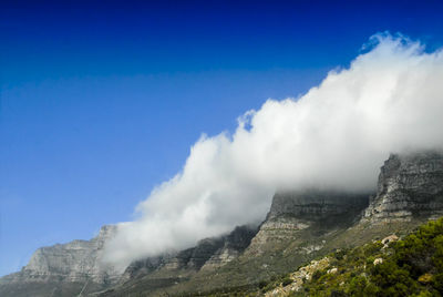 Low angle view of mountains against blue sky