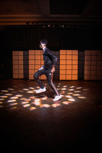 Side view of young man against illuminated ceiling