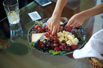 Midsection of woman with fruits on table