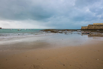 View of beach against cloudy sky