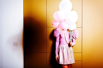 Woman holding balloons in front of her face