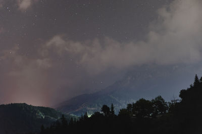 Scenic view of silhouette mountains against sky at night