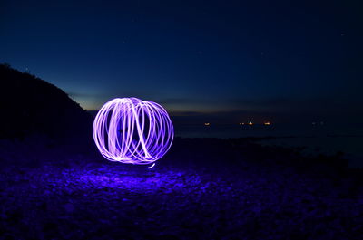 Illuminated blue sea against sky at night