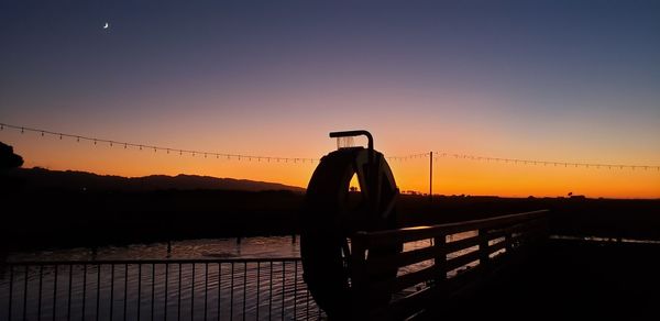 Silhouette bridge against sky during sunset