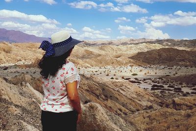 Rear view of woman standing on rock