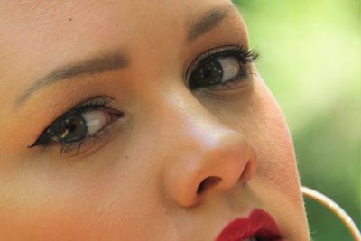 Close-up portrait of woman wearing make-up outdoors