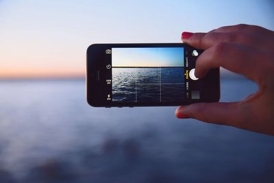 Cropped image of woman holding smart phone