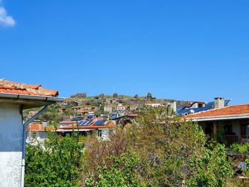 Houses and buildings against clear blue sky