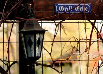 Low angle view of electric lamp hanging on old metal