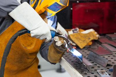 Close-up of man working on metal in workshop