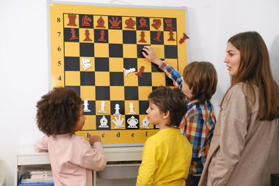 Child thinking hard on chess combinations on the wall on tournament for kids intellectual game