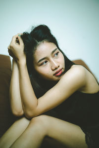 Portrait of young woman against white background