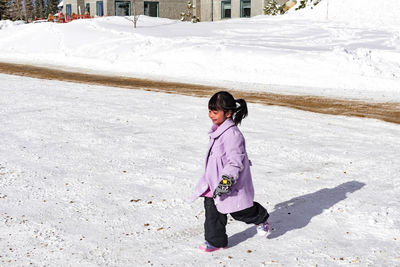 Full length of girl standing in snow